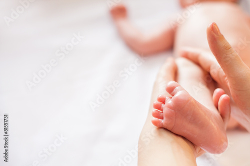 Mother makes massage for happy baby