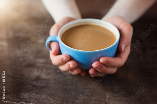 Unrecognizable woman holding a cup of coffee in her hands