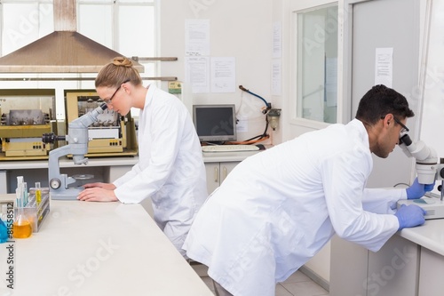 Scientists using microscope