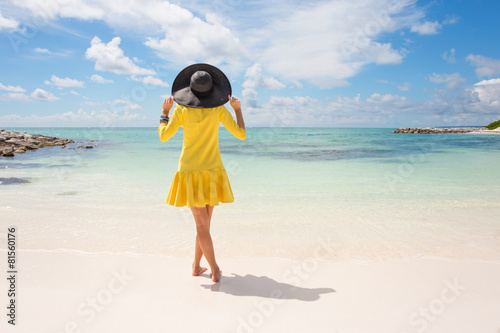 Fashionable woman in yellow dress on the beach