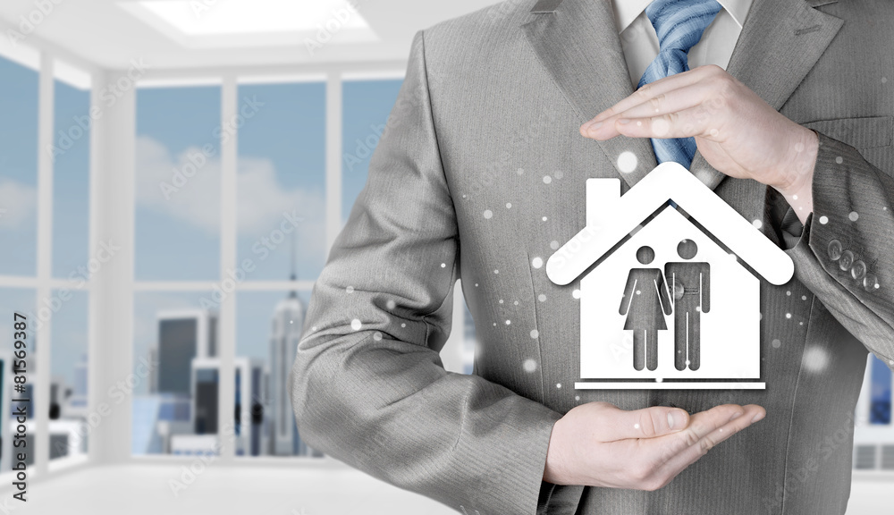 businessman protecting family in home with hands businessman protecting family in home with hands