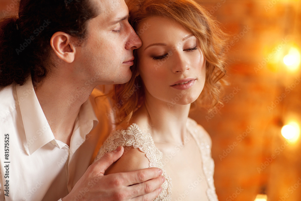Young man and woman together over brick red wall and lights Young man and woman together over brick red wall and lights