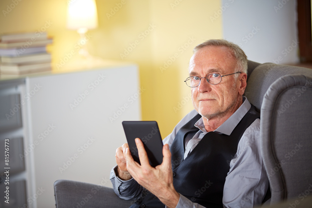Senior man at home reading on a e-book 6 Senior man at home reading on a e-book 6