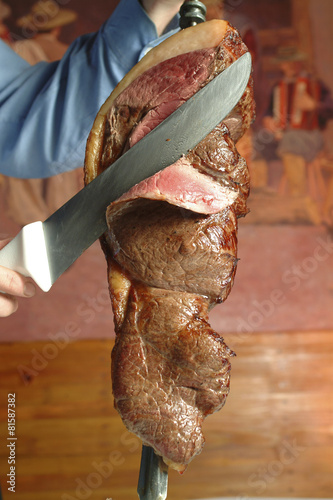 Waiter cutting meat in typical Brazilian barbecue photo