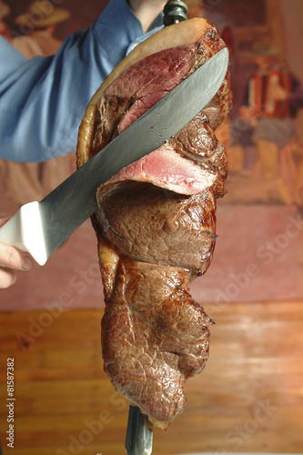 Waiter cutting meat in typical Brazilian barbecue