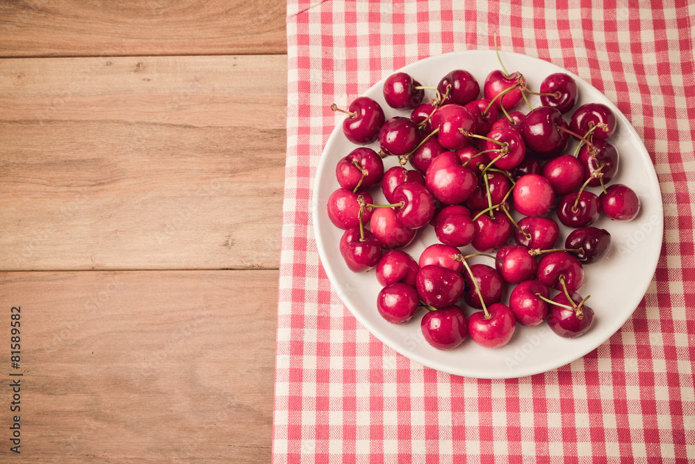 Background with fresh cherries on wooden table with retro filter Background with fresh cherries on wooden table with retro filter