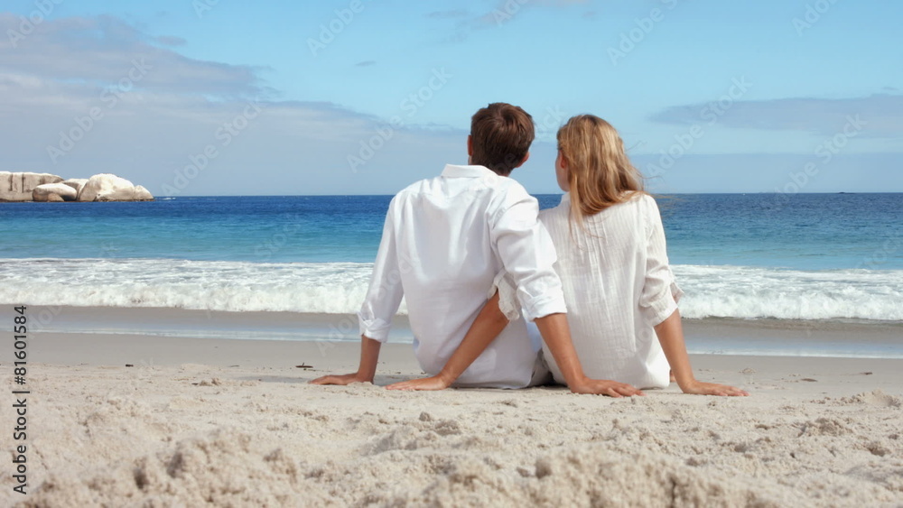Happy couple sitting on the beach Happy couple sitting on the beach