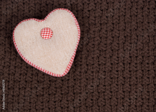 Handmade fabric heart on a brown knitted background