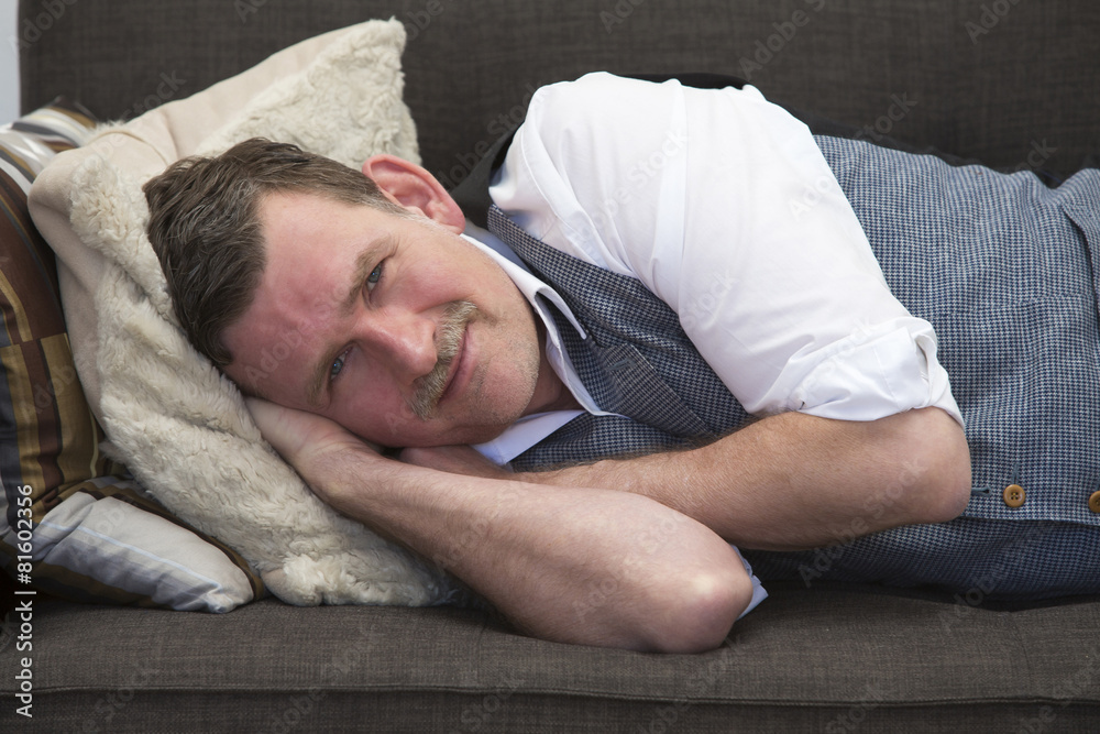 man lying on couch and smiling man lying on couch and smiling