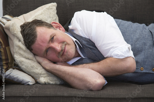 man lying on couch and smiling