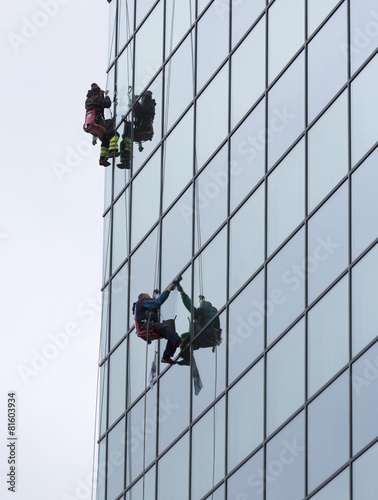 sanitation workers cleaning glass facade hotel
