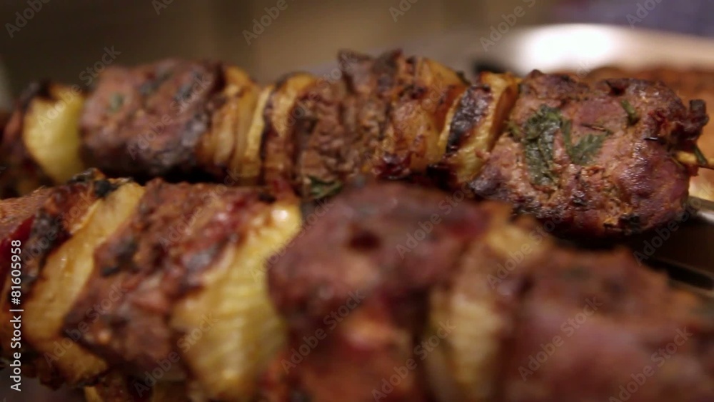 Grilled shashlik with onion on skewers in dish Grilled shashlik with onion on skewers in dish