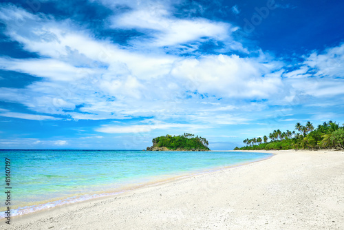 Beautiful tropical beach on the background of palm trees island