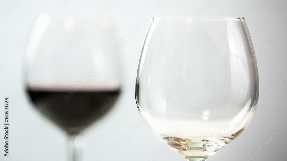 Glasses, one empty and one in background full of red wine Glasses, one empty and one in background full of red wine