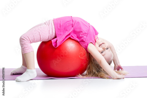 Cute kid girl stretching on pilates ball