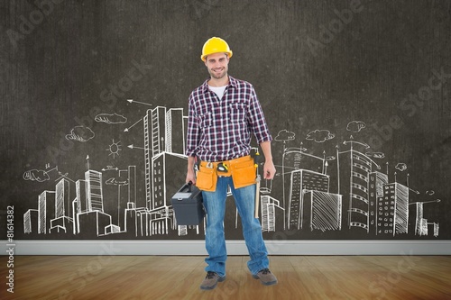 Composite image of happy male hanyman carrying toolbox photo