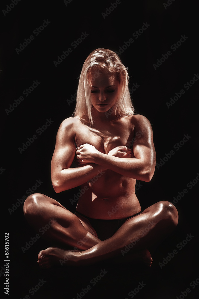 Athletic young woman on a isolated black background Athletic young woman on a isolated black background