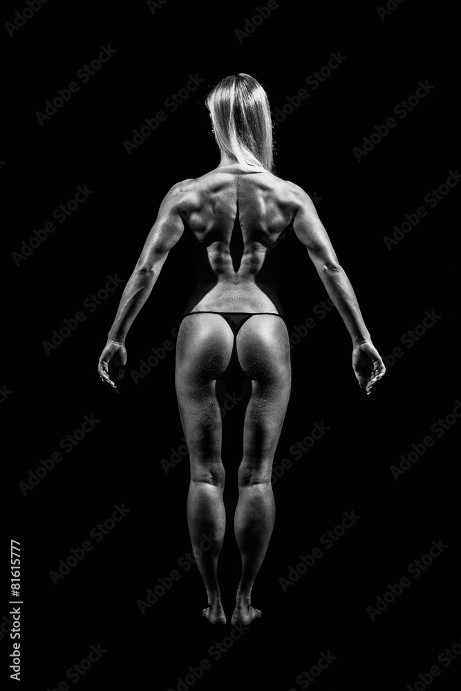 Athletic young woman showing muscles of the back and hands