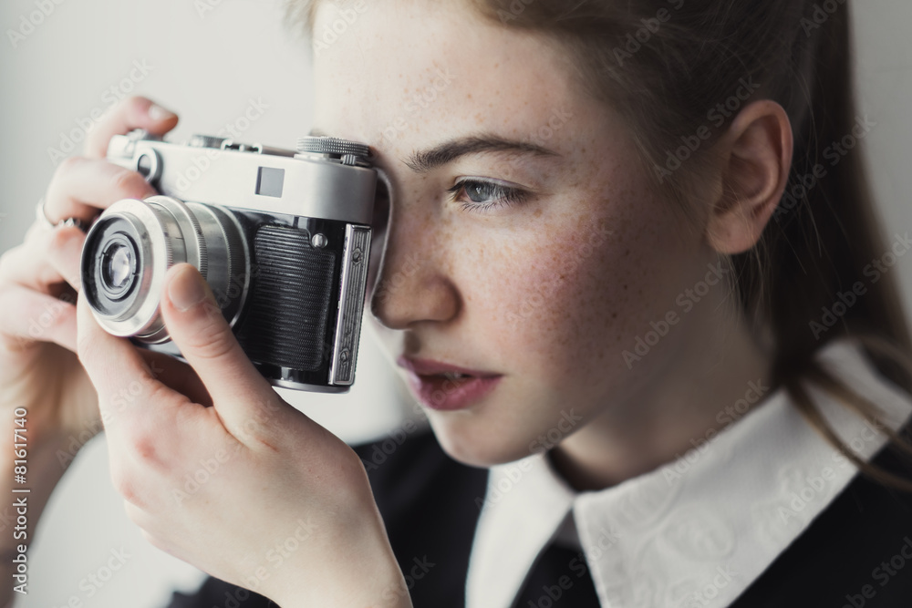 Fototapeta premium face of a beautiful woman photographer and old camera