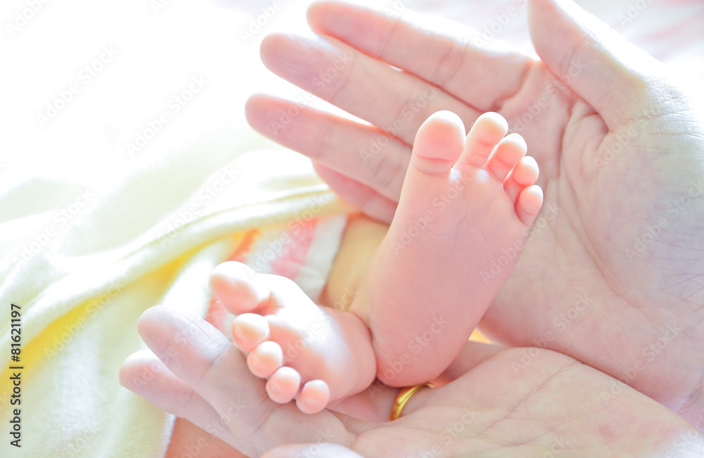 Mother holding newborn baby's feet