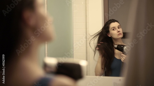 Woman dries hair in the bathroom. photo