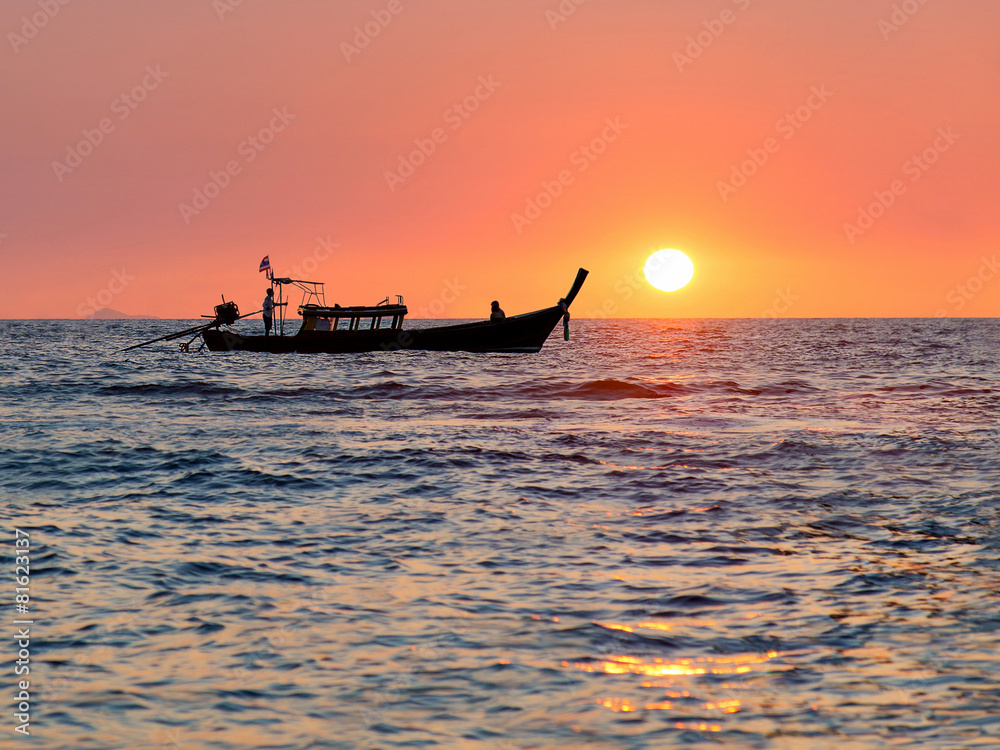 Traditional thai longtail boat against sunset above ocean, Thail