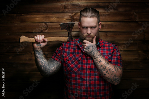 Criminal guy with axe on wood background