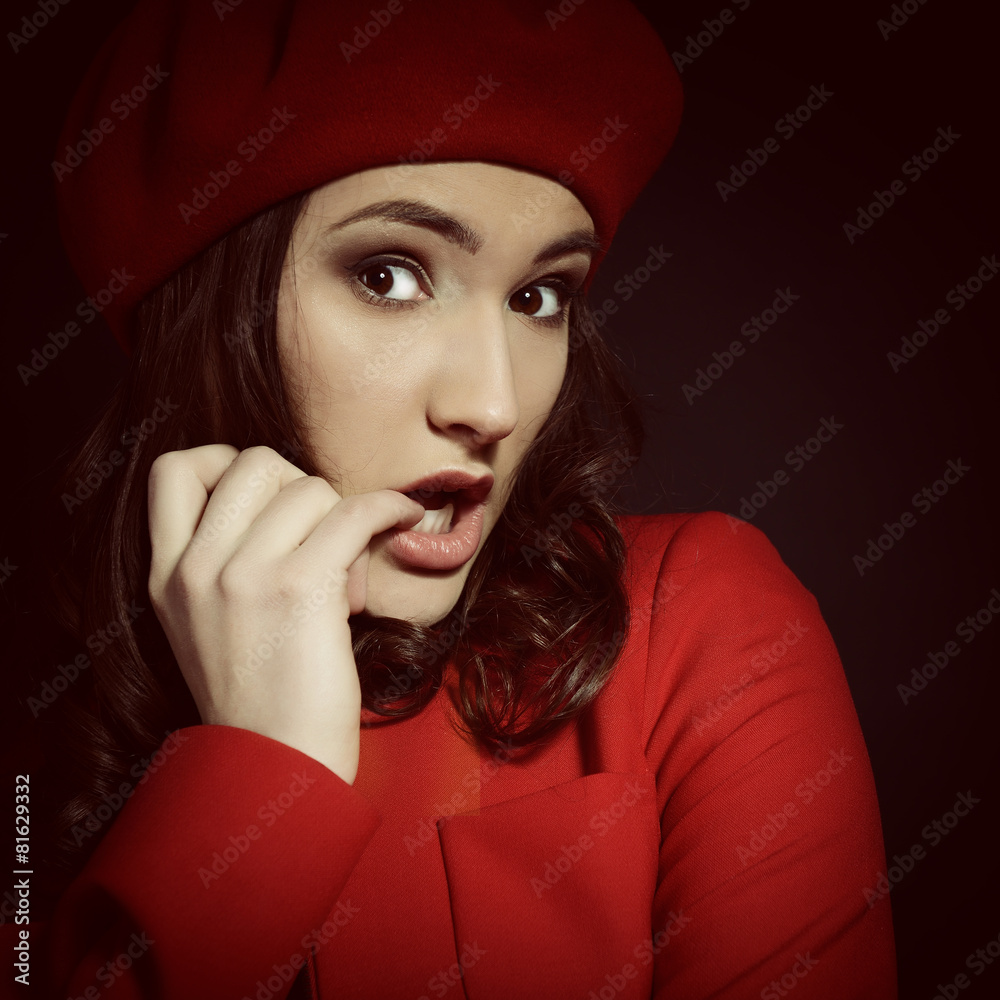 Stylish fashion girl in red suit and beret, posing at studio ove