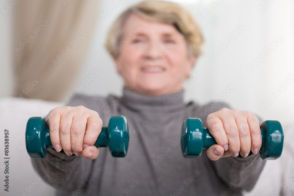 Elder lady training with dumbbells Elder lady training with dumbbells