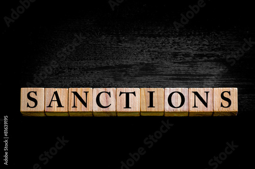 Word SANCTIONS isolated on black background photo