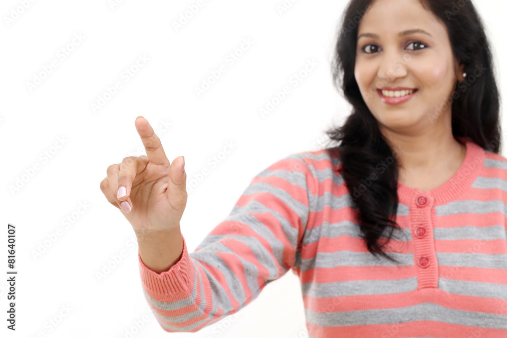 Smiling young woman touching imaginary screen with her finger Smiling young woman touching imaginary screen with her finger