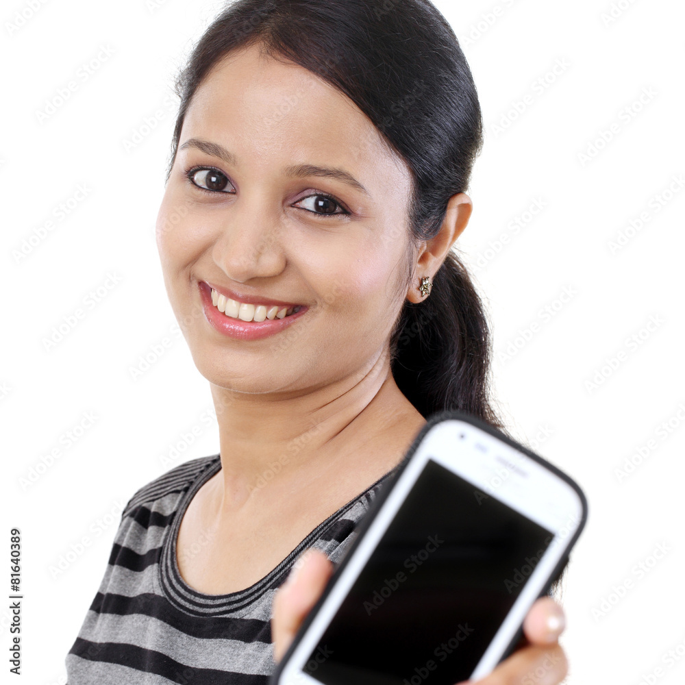 Young woman holding mobile phone against white background
