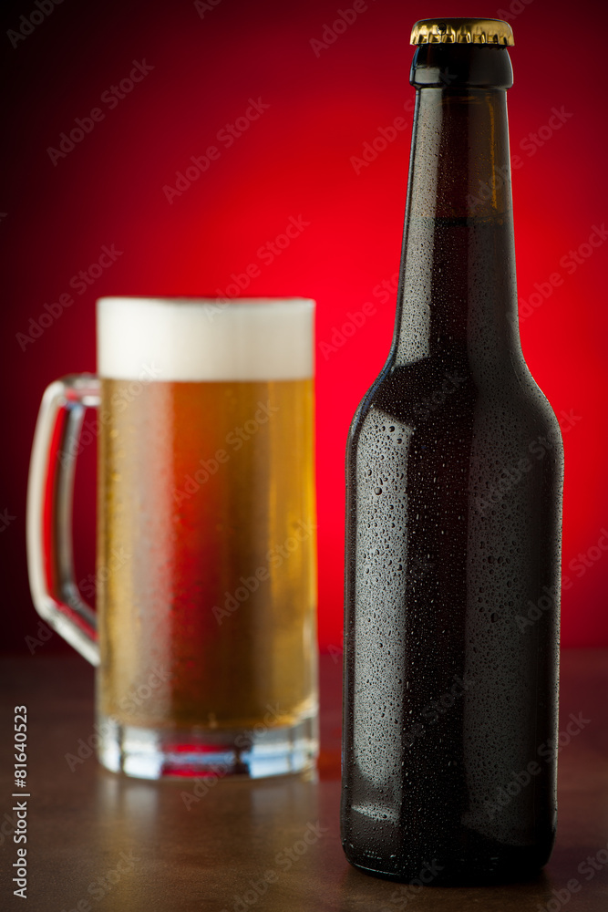 Bottle and glass of beer with waterdrops served on a stone tabl Bottle and glass of beer with waterdrops served on a stone tabl