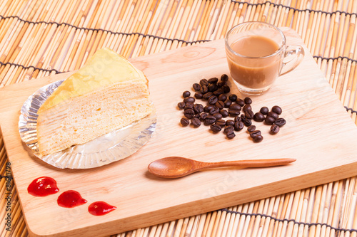 vanilla crape cake and cup of coffee on wood.