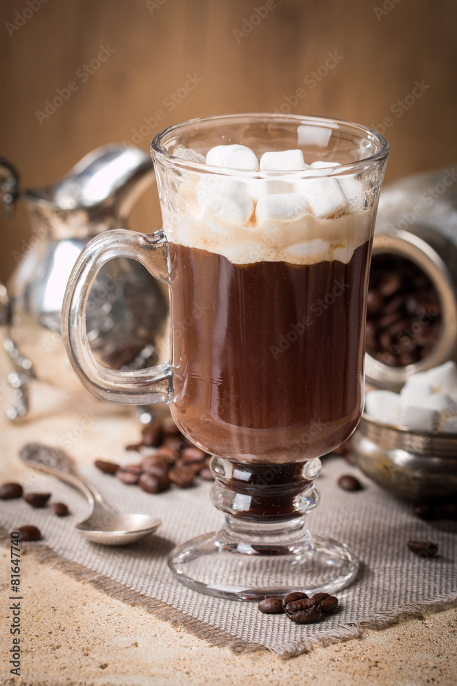 Glass Cup of coffee with marshmallow, milk jug and coffee beans Glass Cup of coffee with marshmallow, milk jug and coffee beans