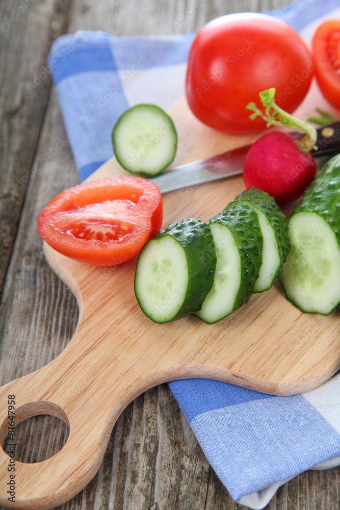 Cucumbers and tomatoes on a cutting board Cucumbers and tomatoes on a cutting board