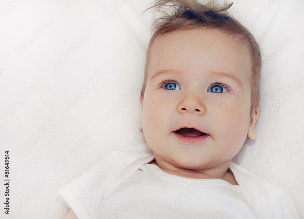 portrait of cute little happy baby boy lying on soft white pillo portrait of cute little happy baby boy lying on soft white pillo