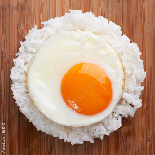 fried egg with steam rice on wooden table