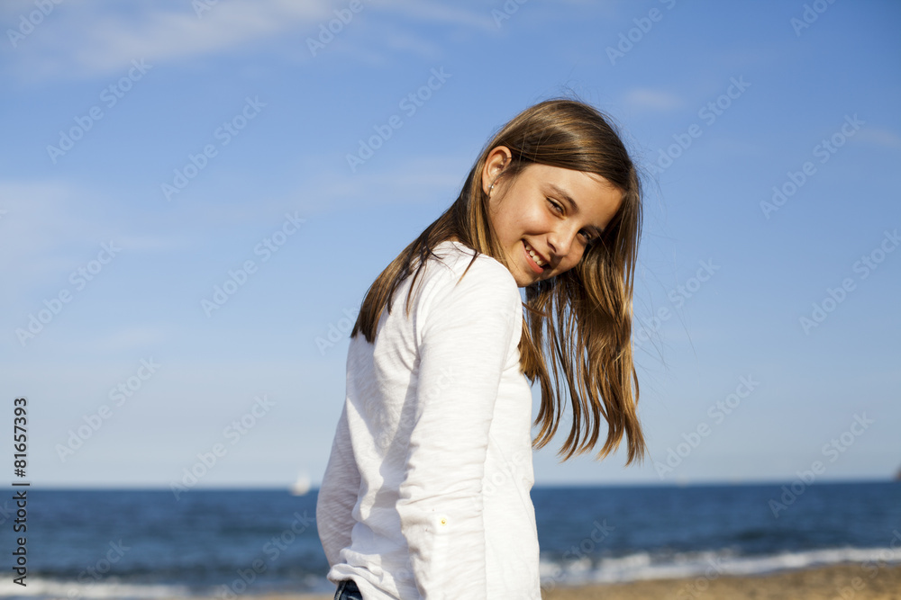 Niña de pelo castaño con camisa blanca en la playa Niña de pelo castaño con camisa blanca en la playa