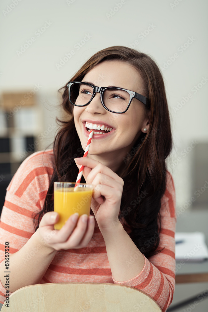 lachende frau trinkt einen smoothie am schreibtisch lachende frau trinkt einen smoothie am schreibtisch