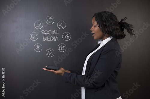 Fototapeta Naklejka Na Ścianę i Meble -  African American woman teacher holding tablet social media