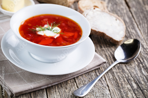 Tasty soup with bread on a wooden background.