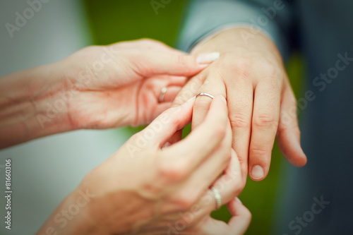 bride placing an engagement ring © kaninstudio