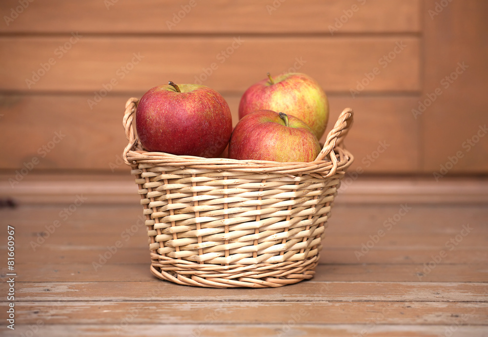Ripe red and yellow apples in light brown wicker basket closeup Ripe red and yellow apples in light brown wicker basket closeup