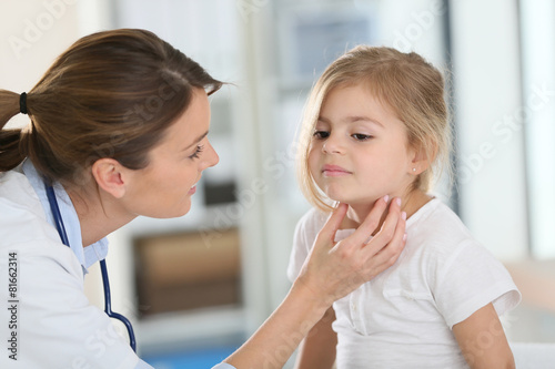 Pediatrician in office checking on child s throat
