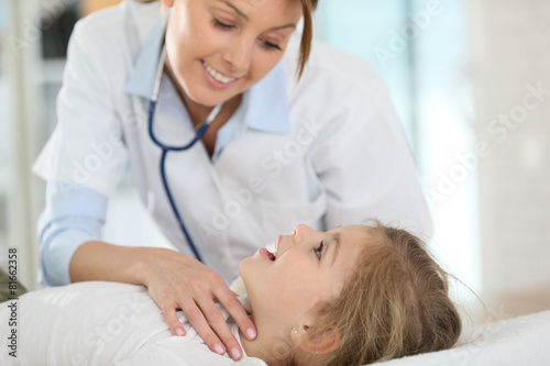 Doctor checking on child's ear