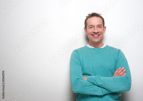 Happy middle aged man smiling with arms crossed