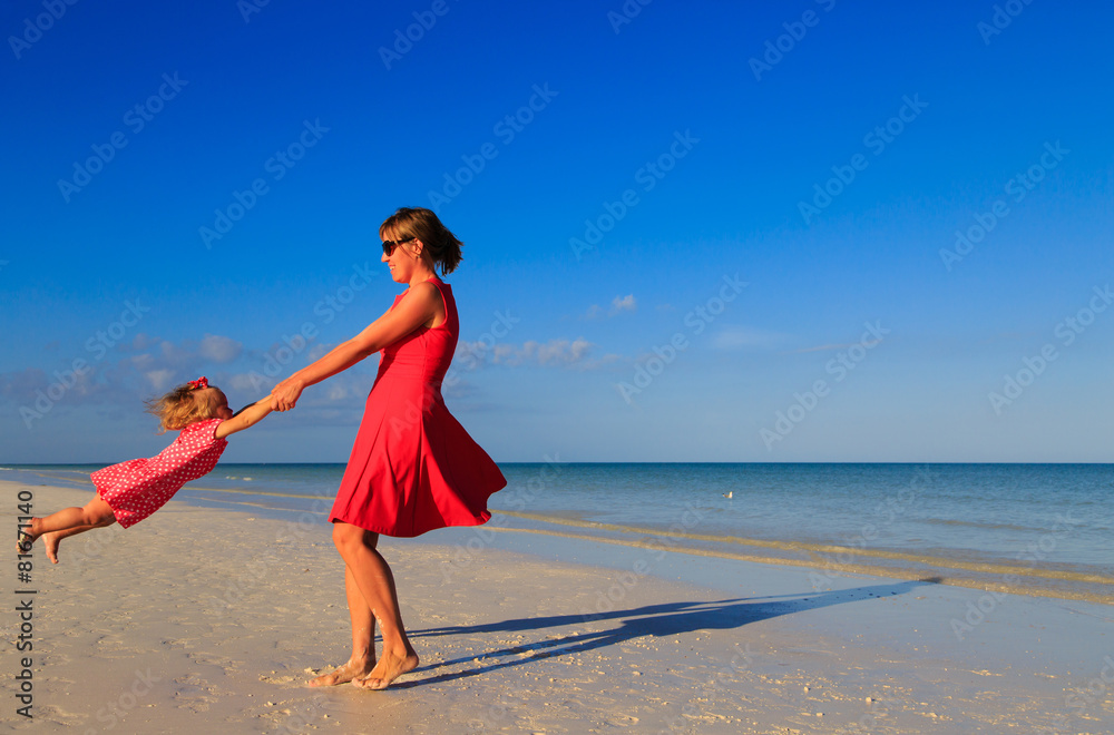 mother and daugher playing on summer beach mother and daugher playing on summer beach