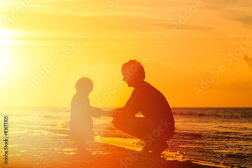 Father and little daughter holding hands at sunset