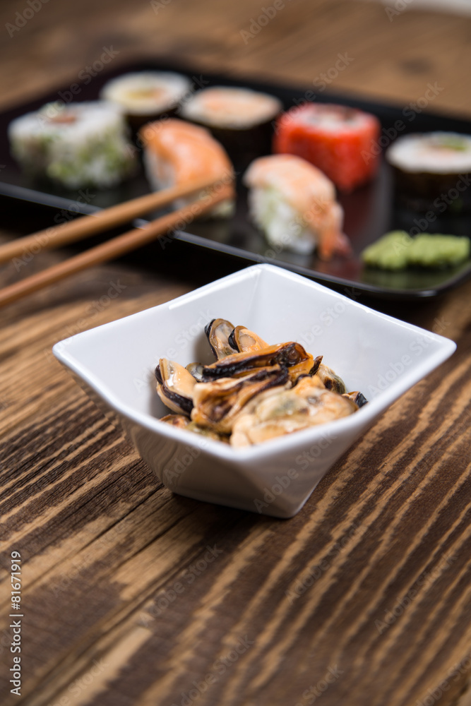 Sushi pieces collection with bamboo chopsticks, isolated on wooden table Sushi pieces collection with bamboo chopsticks, isolated on wooden table